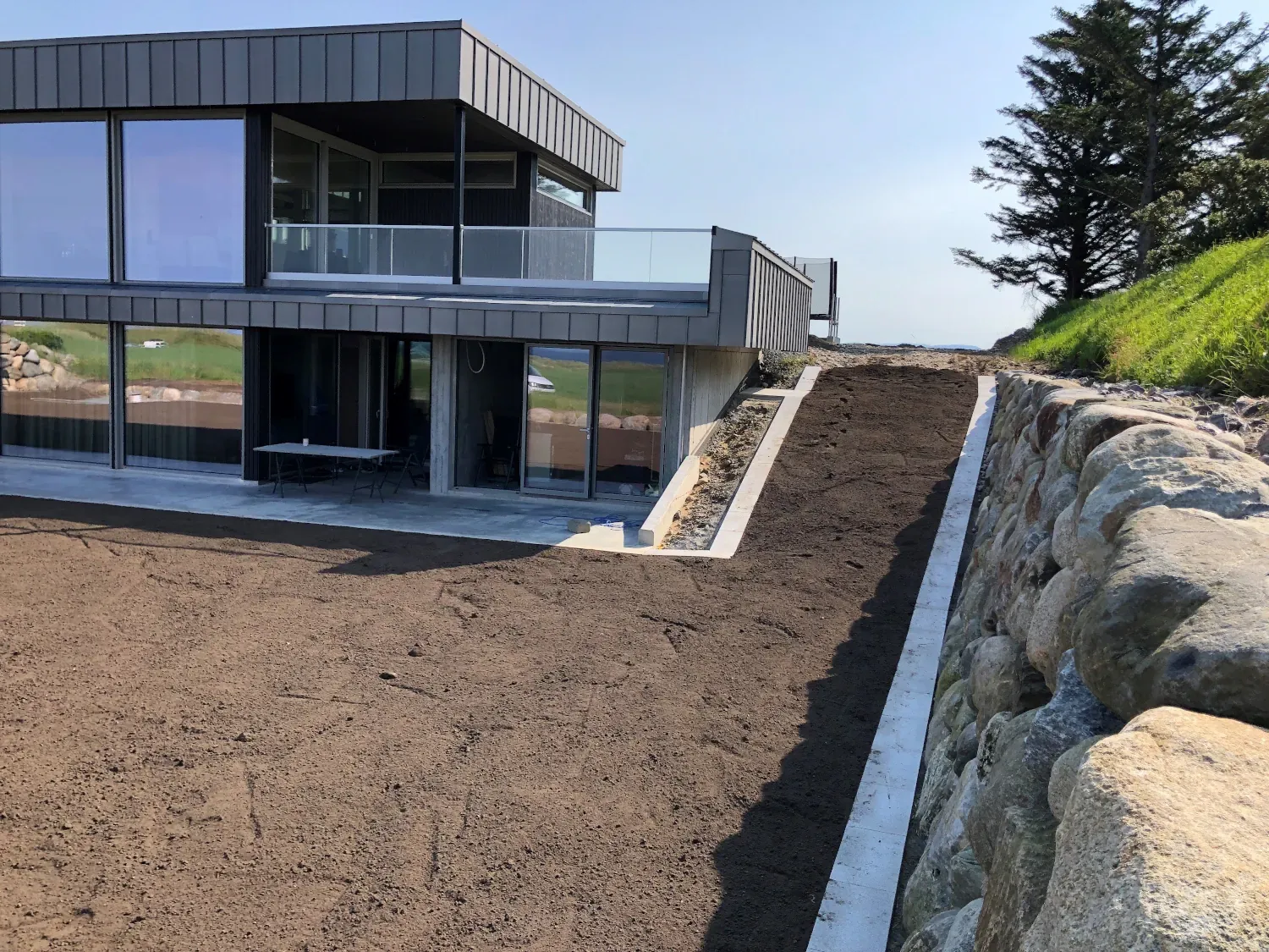 Ferdig opparbeidet uteområde ved bolig med natursteinsmur