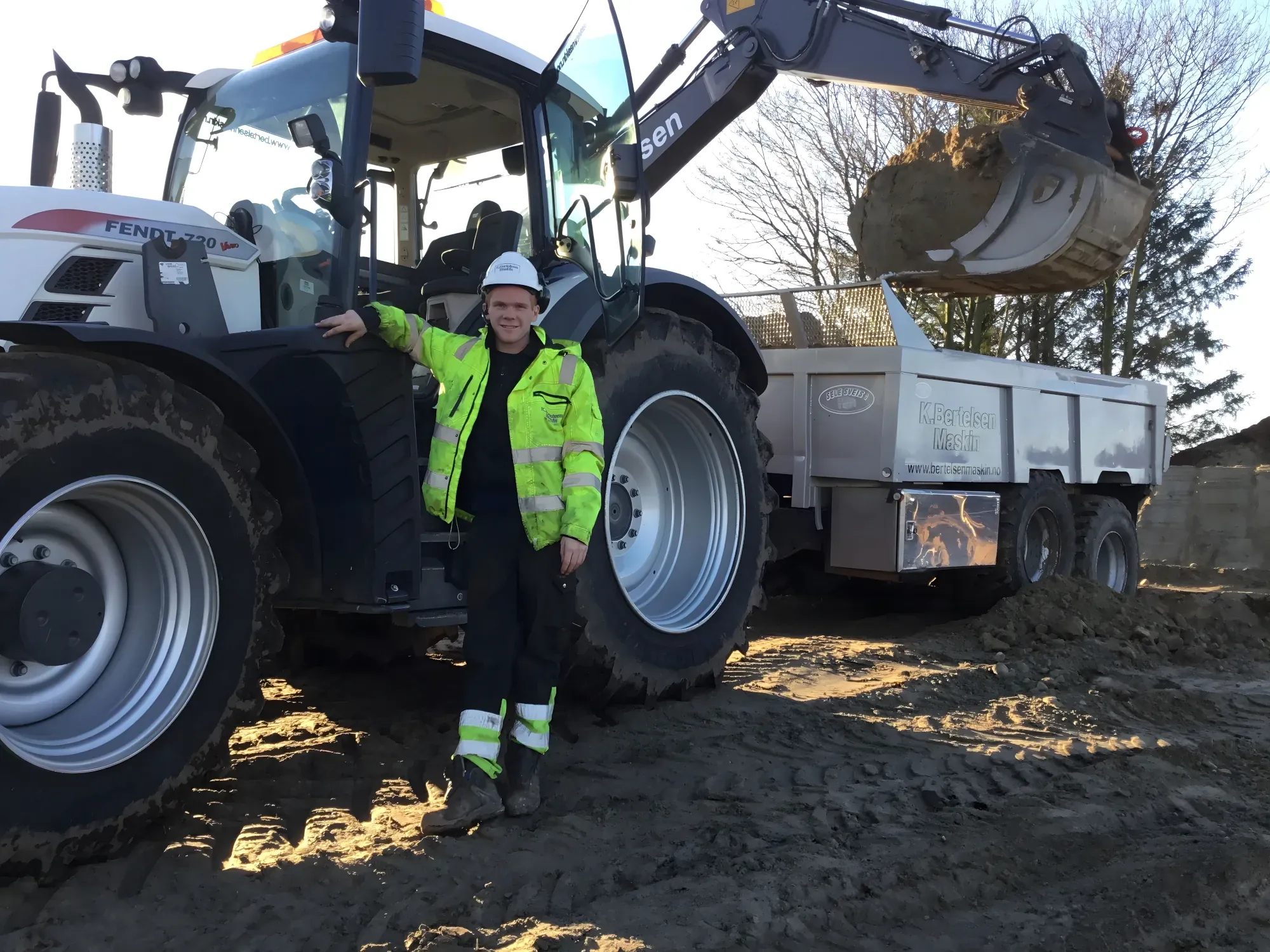 Medarbeider ved traktor med henger